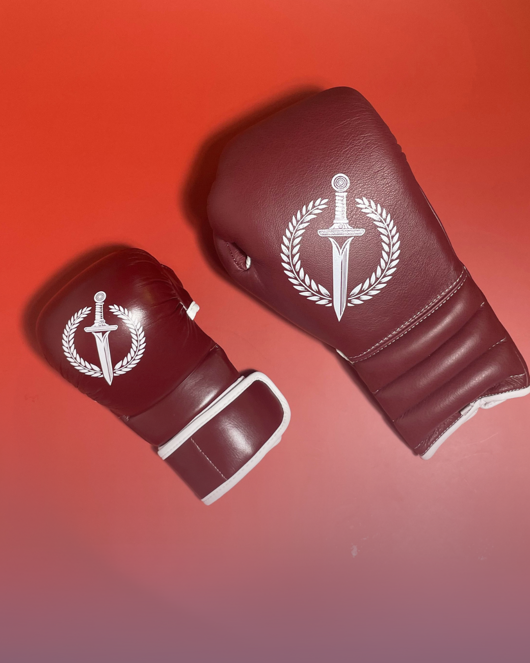Red boxing gloves with a white logo on a red background.