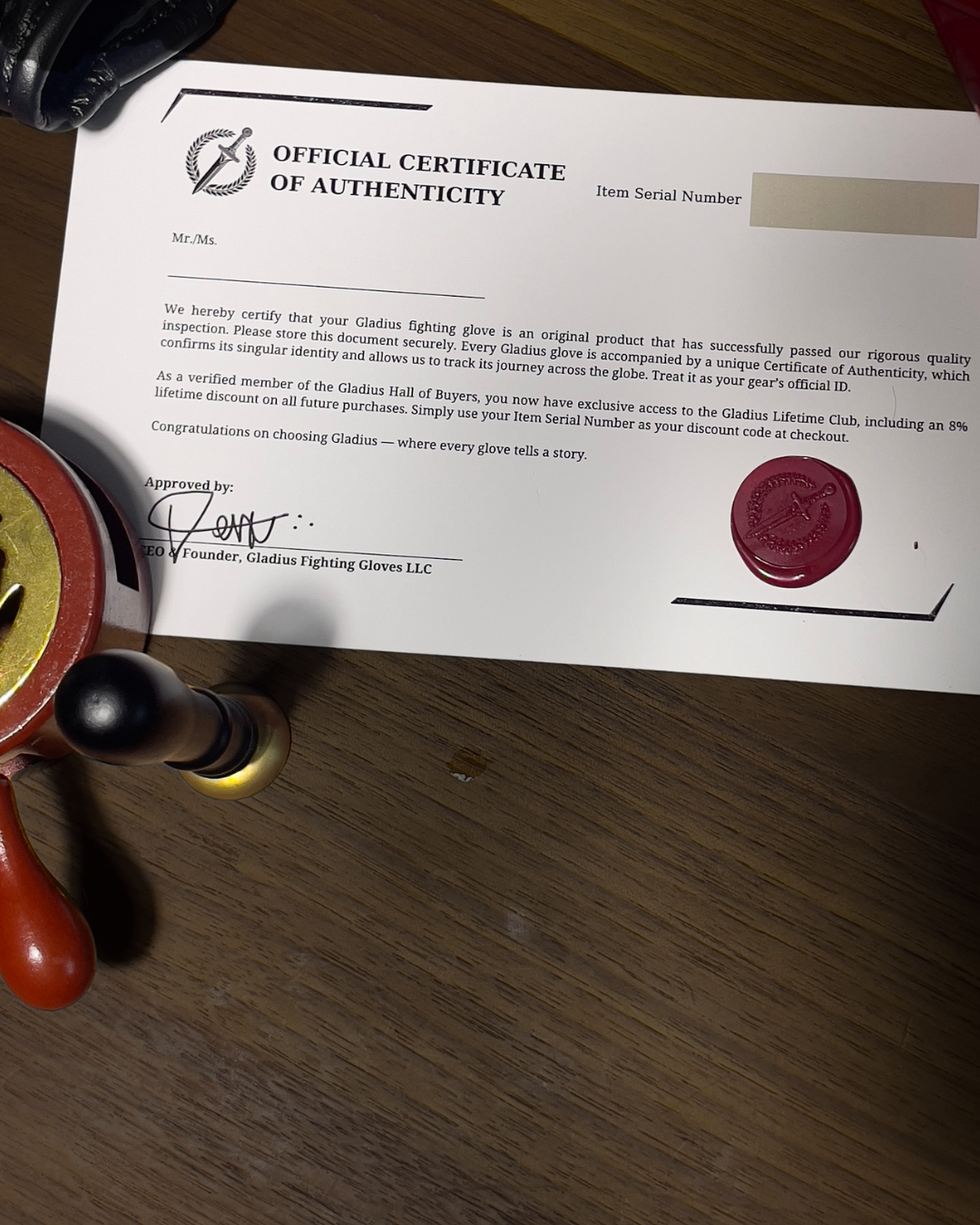 Official Certificate of Authenticity for Gladux fighting gloves on a wooden surface with a stamp.