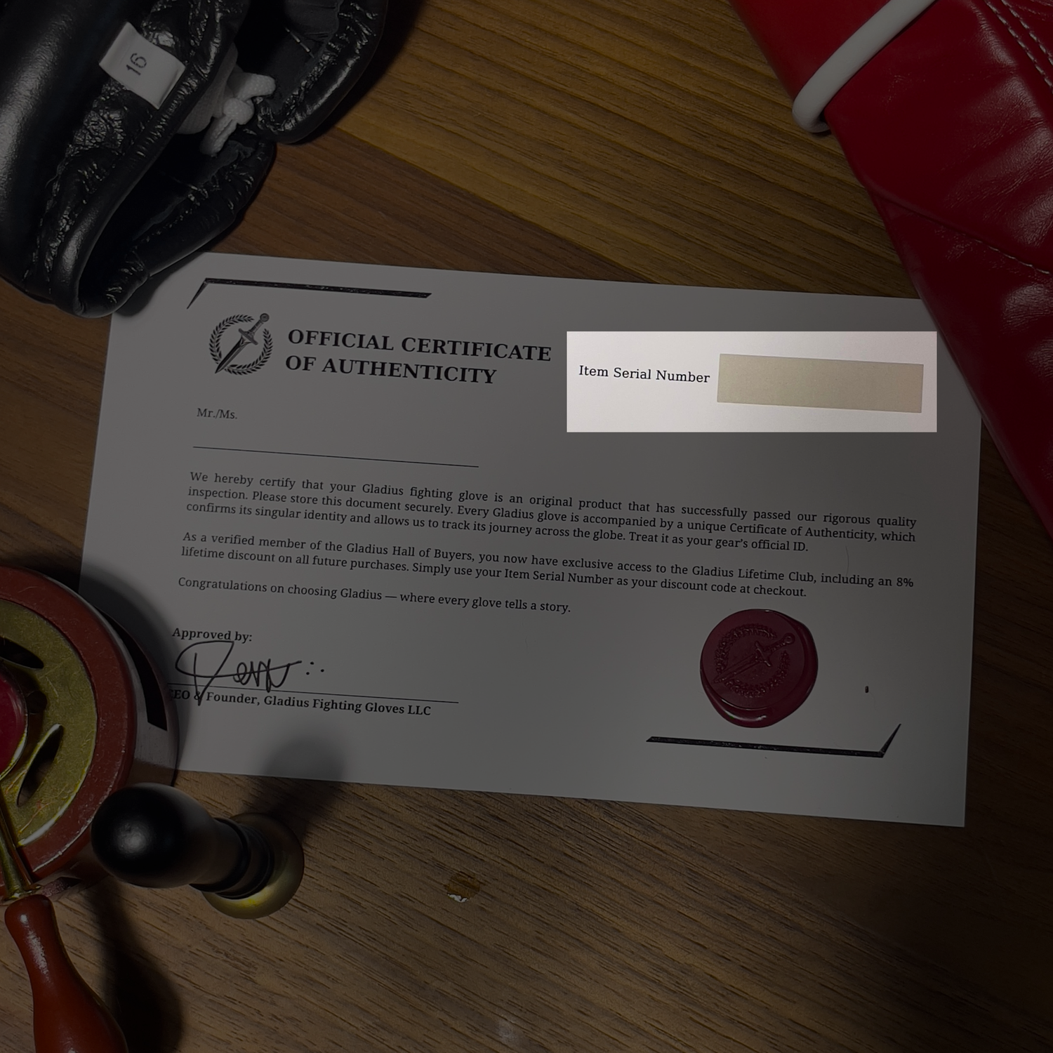 Official Certificate of Authenticity for Gladwin Fighting Gloves on a wooden surface with gloves and a highlight in the item serial number.