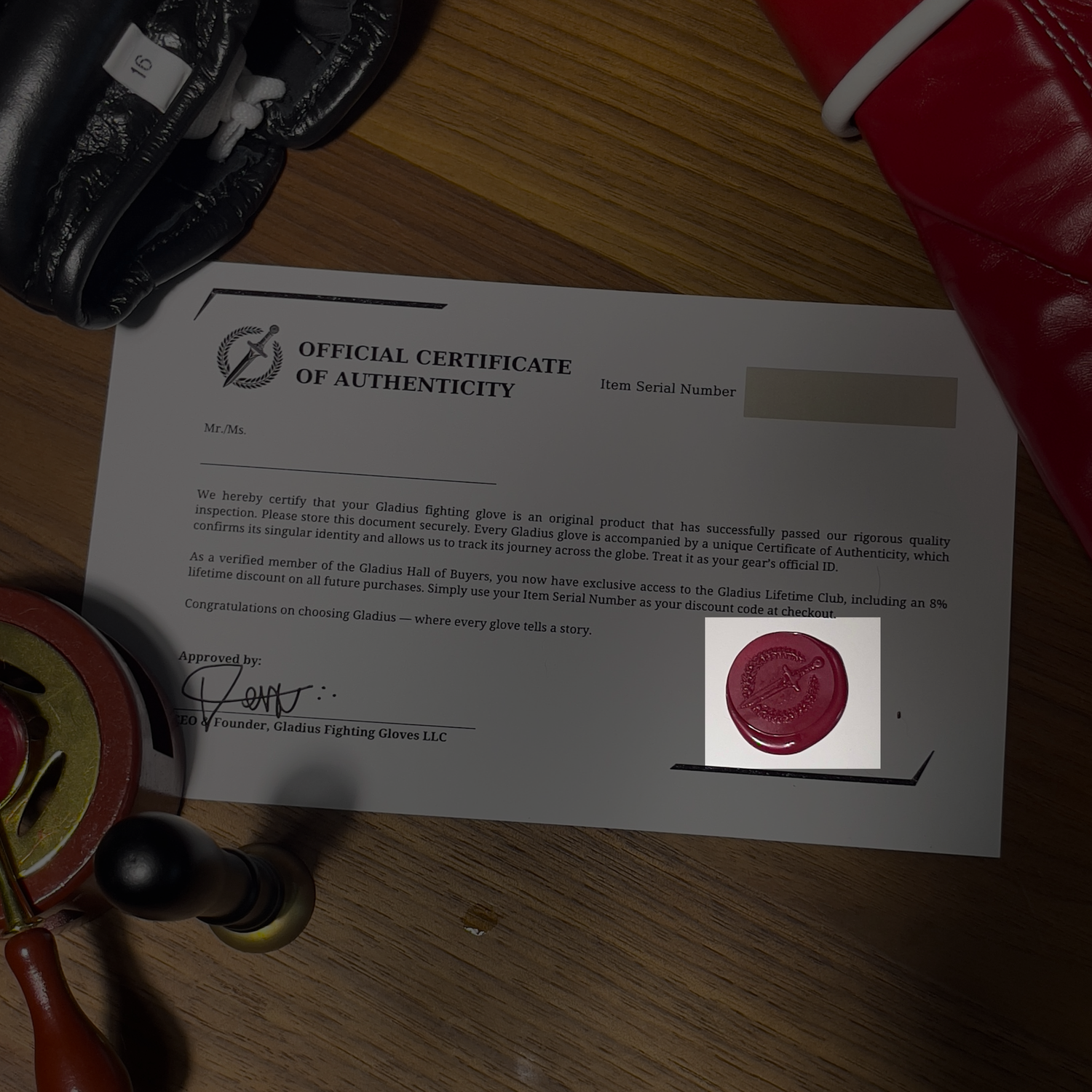 Official Certificate of Authenticity for Gladwin Fighting Gloves on a wooden surface with gloves and a highlight in the wax seal.
