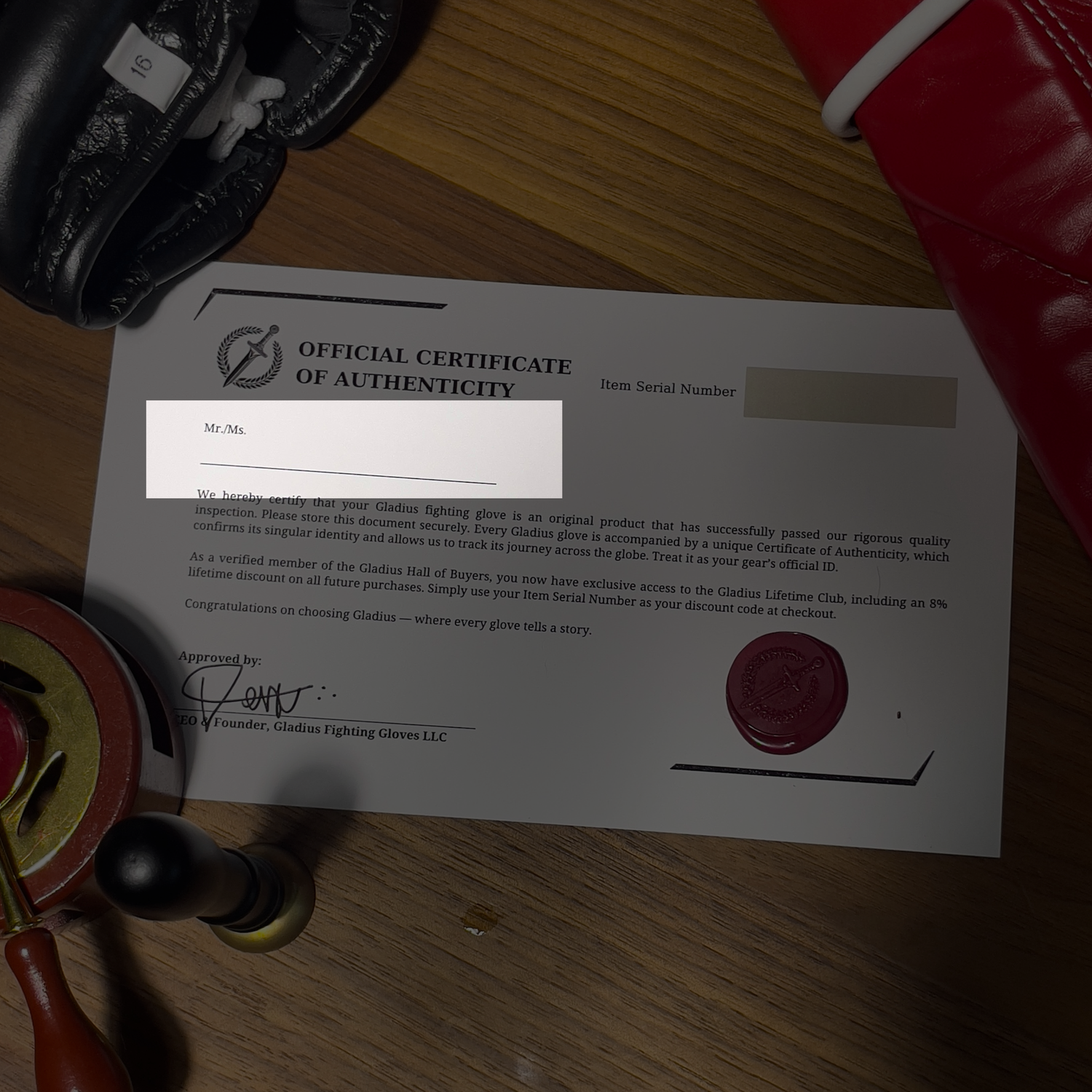 Official Certificate of Authenticity for Gladwin Fighting Gloves on a wooden surface with gloves and a highlight in the name of the customer.