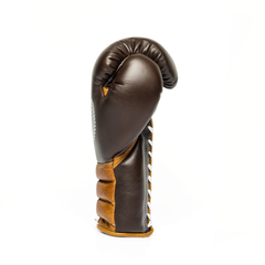 Sideway profile of a brown leather boxing glove on a white background.