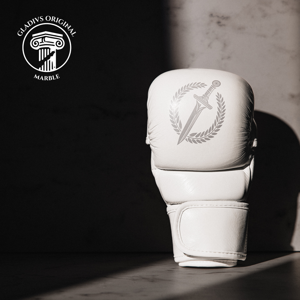 White MMA  glove with a logo on a dark background, featuring the Gladius Marble brand.