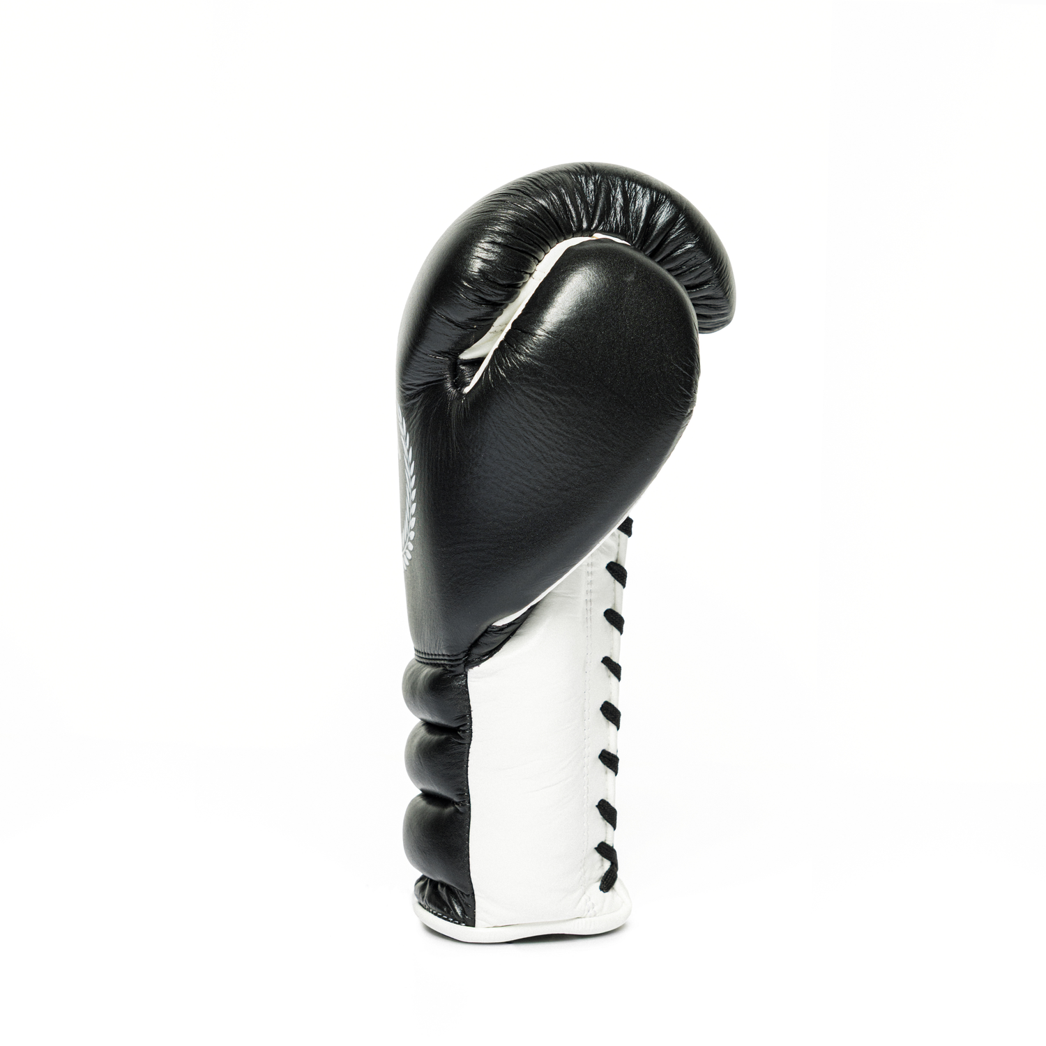Sideways profile of a black and white boxing glove on a white background.
